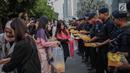 Peserta aksi yang tergabung dalam Mahasiswa dan Pemuda Relawan Cinta NKRI membagikan takjil ke anggota Polri yang bertugas di Gedung Bawaslu RI, Jakarta, Minggu (26/5). Aksi simpatik sebagai wujud apresiasi kepada anggota Polri-TNI yang menjaga keamanan aksi 22 Mei 2019. (Liputan6.com/Faizal Fanani)