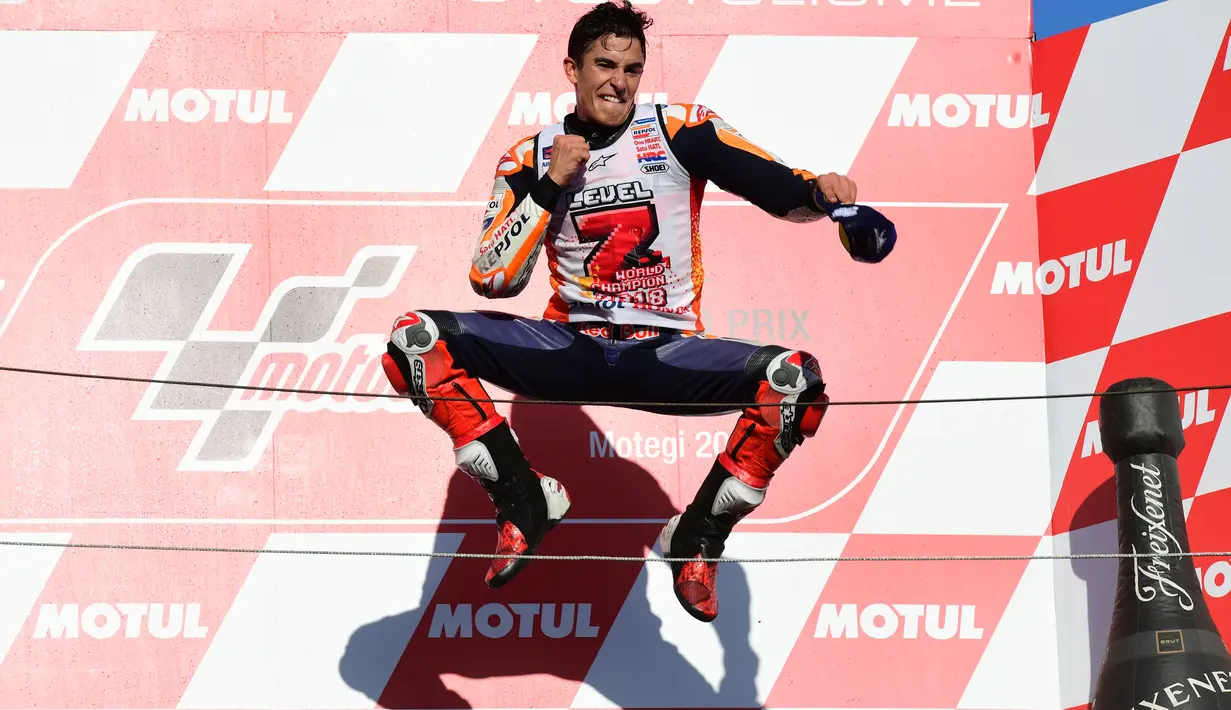 Pembalap Repsol Honda, Marc Marquez berselebrasi di atas podium setelah memenangi balapan MotoGP Jepang 2018 di Twin Ring Motegi, Minggu (21/10). Kemenangan Marquez di Jepang sekaligus membuatnya menjadi juara dunia MotoGP 2018. (Martin BUREAU / AFP)