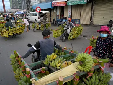 Penjual pisang, menjual buah dari sepeda motor mereka, menunggu pelanggan di sepanjang jalan di Phnom Penh (13/10/2021). Phnom Penh adalah kota terbesar di Kamboja. (AFP/Tang Chhin Sothy)