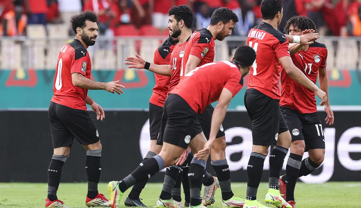 Penyerang Mesir Mohamed Salah (kiri) berselebrasi setelah mencetak gol ke gawang Maroko pada pertandingan perempat final Piala Afrika (CAN) 2021 di Stade Ahmadou Ahidjo di Yaounde (30/1/2022). Mesir menang atas Maroko 2-1. (AFP/Kenzo Tribouillard)