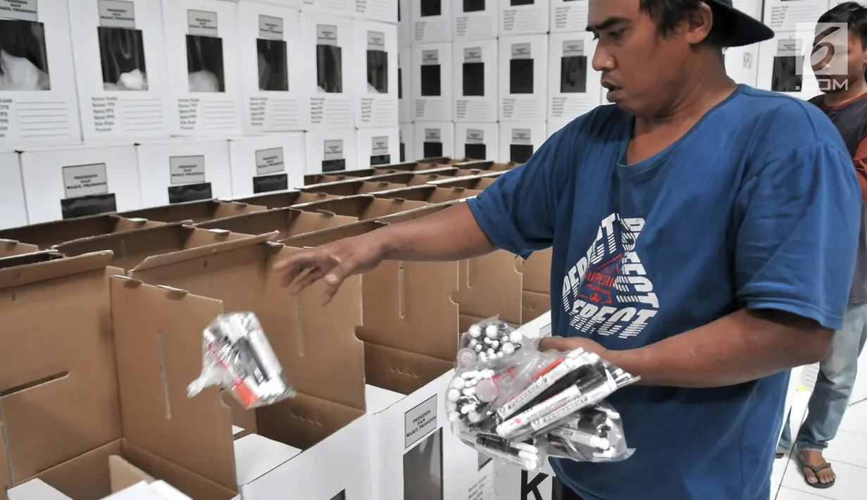 Pekerja memasukkan paket alat tulis untuk mencoblos ke dalam kotak suara Pemilu 2019 di Gudang Logistik KPU Kota Bekasi, Jawa Barat, Rabu (20/12). (Merdeka.com/Iqbal S. Nugroho)