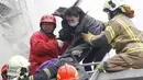 Petugas penyelamat mengevakuasi seorang korban di gedung apertemen yang runtuh akibat gempa 6,4 SR  di Tainan, (6/2). Menurut data meteorologi gempa terjadi pada kedalaman 16,7 kilometer di bawah permukaan laut. (REUTERS/Stringer)