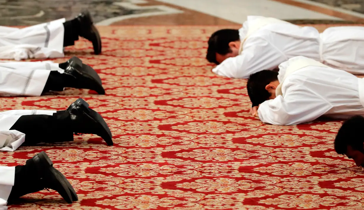 Para imam baru berbaring menghadap lantai selama upacara penahbisan yang dipimpin Paus Fransiskus di Basilika Santo Petrus, Vatikan, Minggu (22/4). Para imam terdiri dari sejumlah negara. (AP Photo/Alessandra Tarantino)
