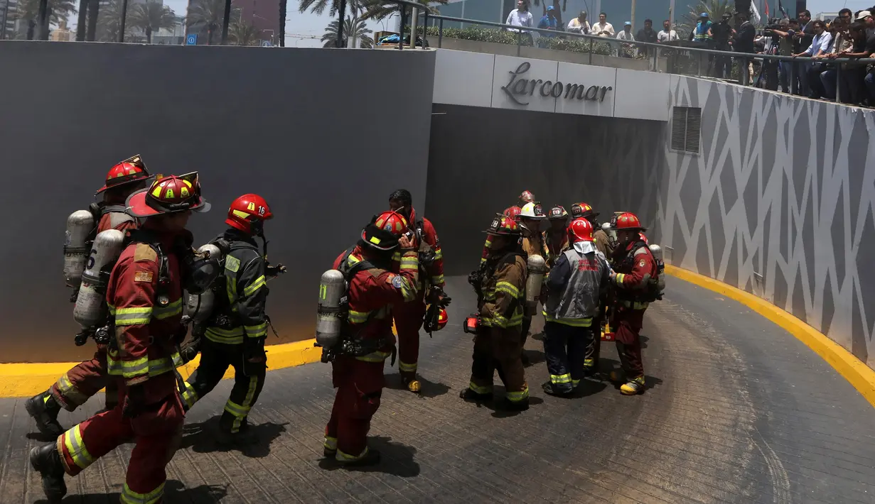 Petugas pemadam berusaha memadamkan  kebakaran yang melanda Mal Larcomar di pusat Ibu Kota Peru, Lima, Rabu (16/11). Petugas pemadam mengatakan api mulai muncul di bioskop pada salah satu lantai terendah mal. (REUTERS/Guadalupe Pardo)
