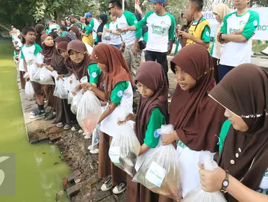 Para murid SDN Pamarican 2 Serang melakukan sebar sejuta ikan di danau Tasikardi, Serang Baten, Sabtu (28/5). Jurnalis Joran Indonesia (Jojoners) dan PT Hero Supermarket Tbk mengadakan gerakan kepedulian sosial dan lingkungan. (Liputan6.com/Angga Yuniar)