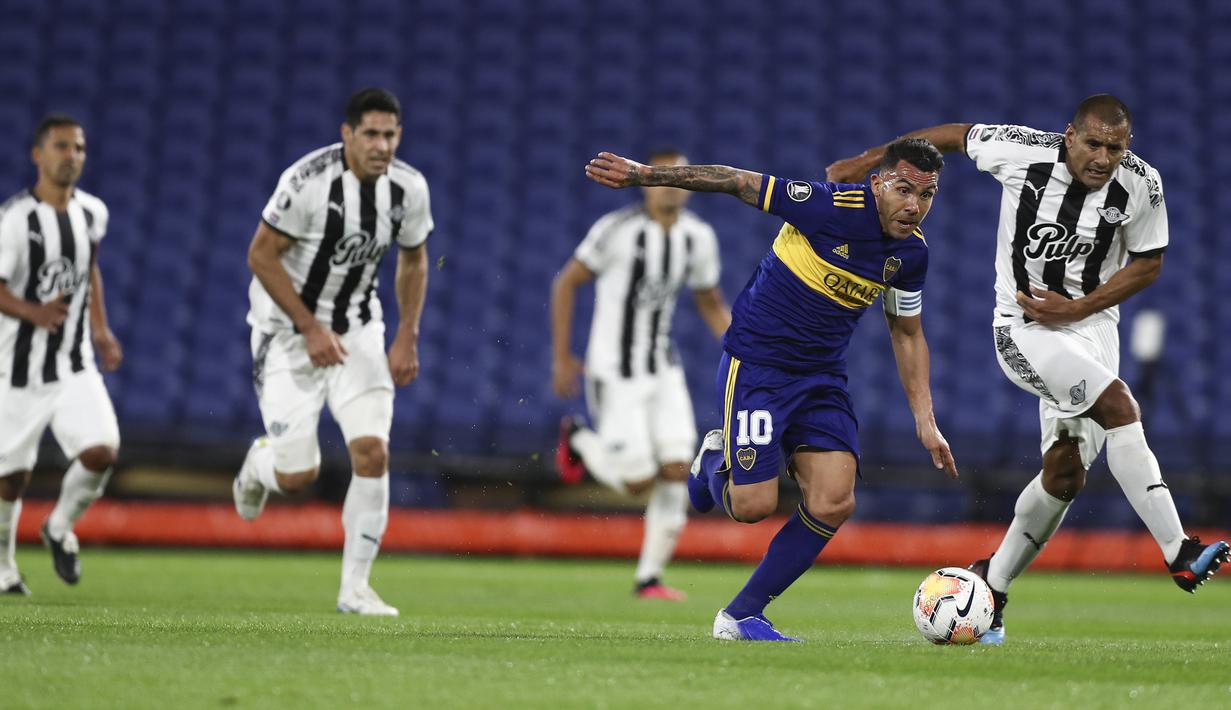 Penyerang Boca Juniors, Carlos Tevez, berusaha melewati pemain Libertad pada laga grup H Copa Libertadores di Estadio La Bombonera, Rabu (30/9/2020) dini hari WIB. Boca Juniors bermain imbang 0-0 atas Libertad. (Agustin Marcariana/Pool via AP)