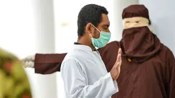 Seorang pria saat dihukum cambuk dengan tongkat rotan oleh anggota polisi Syariah di sebuah gedung umum di Banda Aceh (24/9/2020). Pria tersebut dihukum akibat melakukan aktivitas seksual dengan anak di bawah umur. (AFP/Chaideer Mahyuddin)