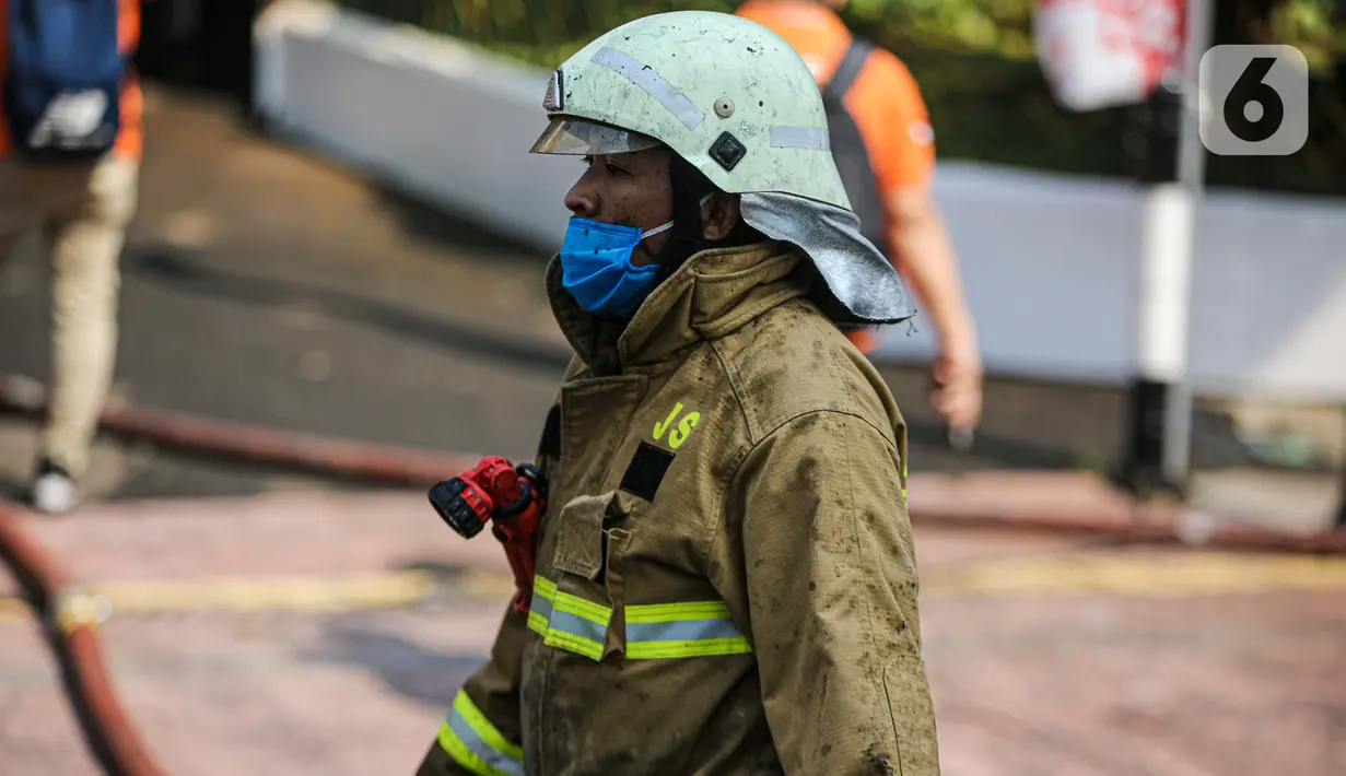 Petugas pemadam kebakaran usai melakukan pendingan di Gedung Kejaksaan Agung RI yang terbakar, Minggu (23/8/2020). Kebakaran di gedung Kejaksaan Agung pada Sabtu (22/8) malam akhirnya padam dan kini bangunan tersebut menyisakan bagian hitam legam. (Liputan6.com/Faizal Fanani)