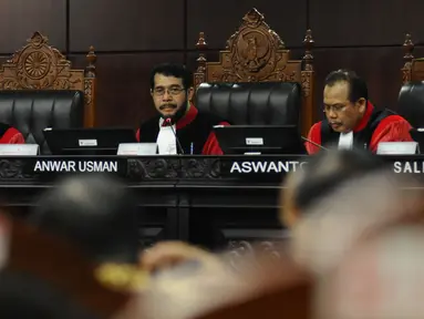 Wakil Ketua MK Anwar Usman (tengah) memimpin sidang lanjutan pengujian UU Jaminan Halal terkait ketentuan produk halal di gedung Mahkamah Konstitusi, Jakarta, Rabu (12/7). Sidang mendengarkan keterangan saksi dan ahli. (Liputan6.com/Helmi Fithriansyah)