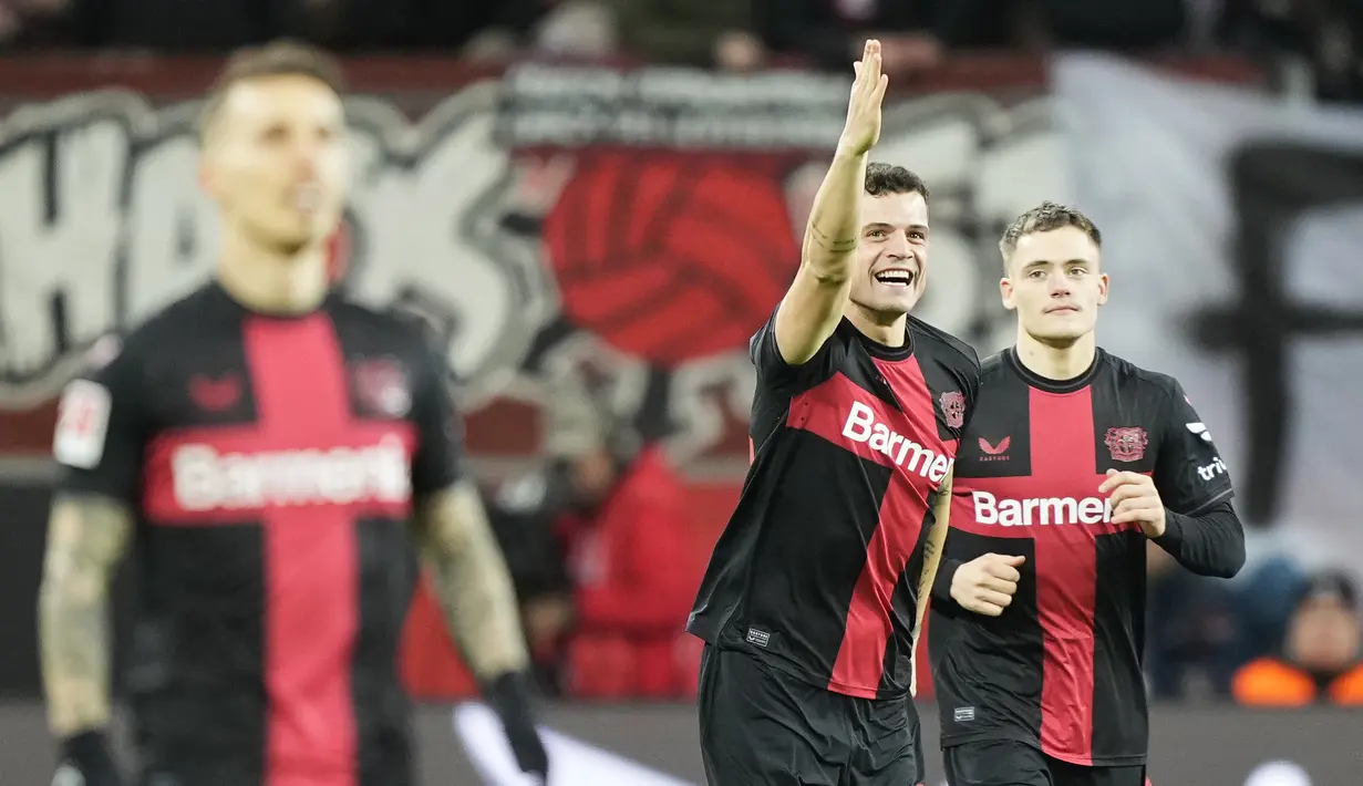 Pemain Bayer Leverkusen, Granit Xhaka, melakukan selebrasi setelah mencetak gol ke gawang  Mainz dalam duel pekan ke-23 Bundesliga di Stadion BayArena, Sabtu (24/2/2024). Leverkusen menang dengan skor 2-1. (AP Photo/Martin Meissner)
