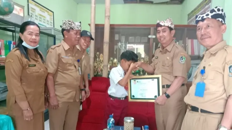 Kepala Dinas Pendidikan Banyuwangi Surtno menyerahkan penghargaan berupa golden tiket masuk SMP kepada penyanyi cilik asal Banyuwangi Farel Prayoga (Istimewa)