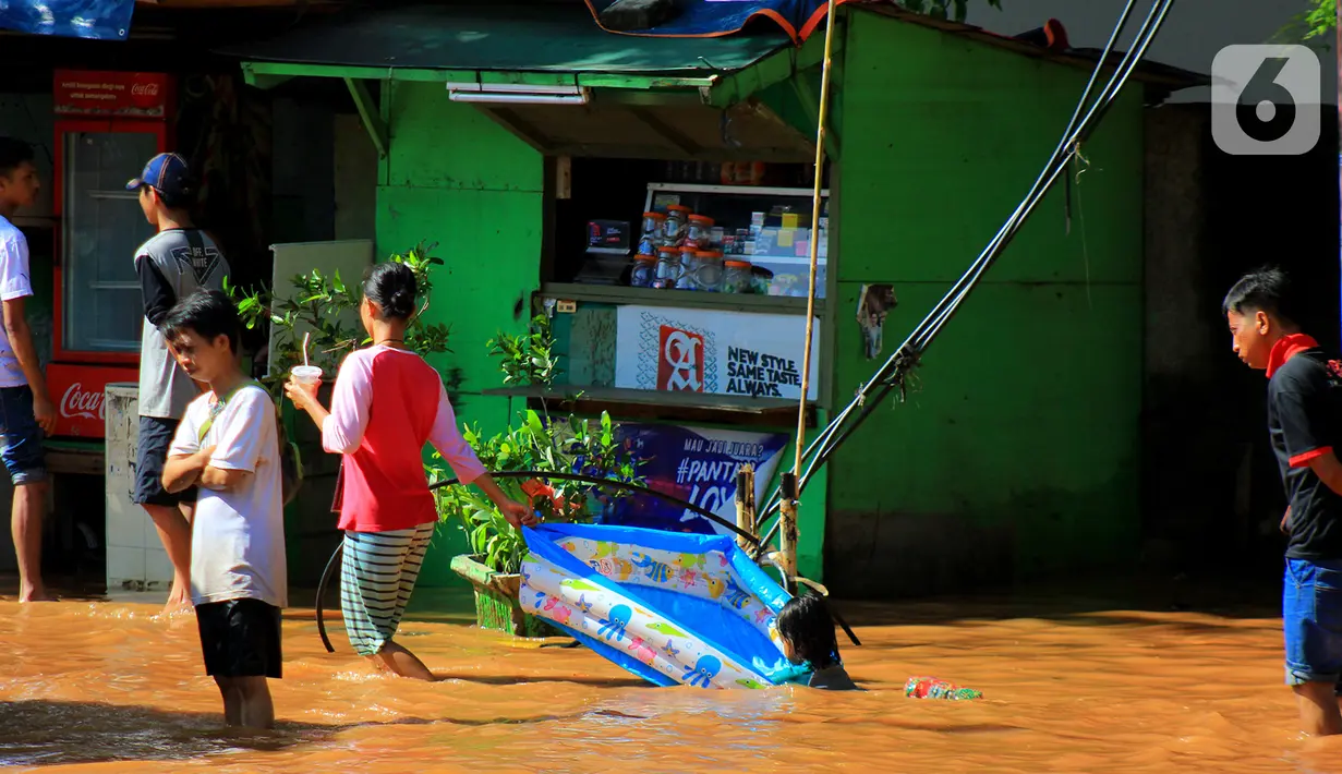 Seorang anak bermain air di Jalan Raya Kayu Putih, Jakarta, Minggu (23/2/2020). Usai hujan deras sejak Sabtu (22/2) malam hingga dini hari menyebabkan banjir di Jalan Raya Kayu Putih, Jakarta, Minggu (23/2). (merdeka.com/Magang/Muhammad Fayyadh)