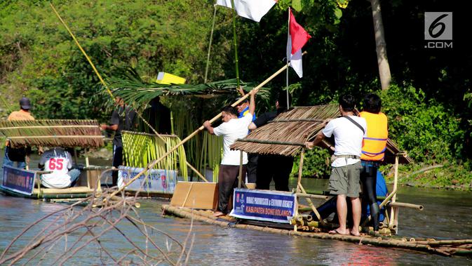 Peserta menyusuri sungai Bone menggunakan rakit tradisional di Gorontalo, Sabtu (23/3). Kegiatan ini dilaksanakan sebagai upaya meningkatkan kesadaran masyarakat Bonebol untuk bisa menjaga kelestarian sungai. (Liputan6.com/Arfandi Ibrahim)