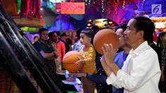 Presiden Joko Widodo dan cucu Jan Ethes Srinarendra menyempatkan diri bermain basket di Sun Plaza Medan, Sumatera Utara, Jumat (24/11). Jokowi tiba di lokasi mengenakan kemeja putih lengan panjang dan celana hitam. (Liputan6.com/Johan Tallo)
