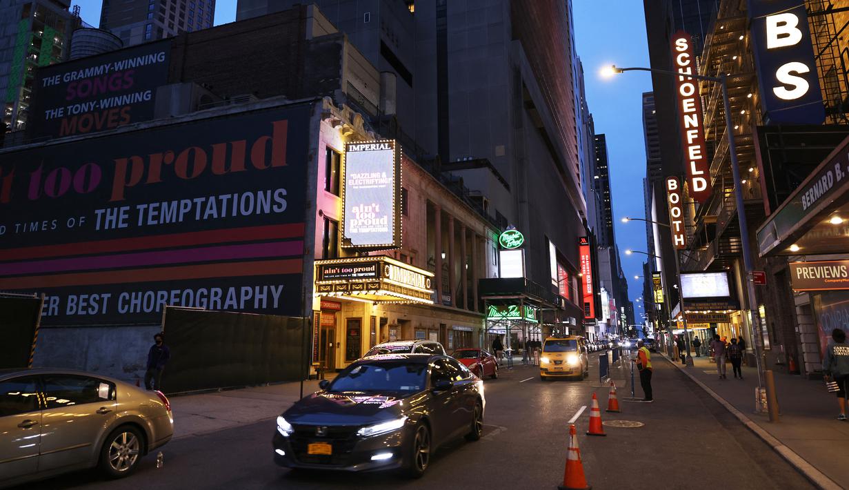 Mobil melewati gedung-gedung teater di Theater District di Manhattan, New York City, Kamis (6/5/2021). Gubernur Andrew Cuomo mengumumkan teater Broadway akan dibuka kembali dalam kapasitas penuh mulai 14 September, sejak ditutup Maret 2020 karena COVID-19. (MICHAEL M. SANTIAGO/GETTY IMAGES VIA AFP)