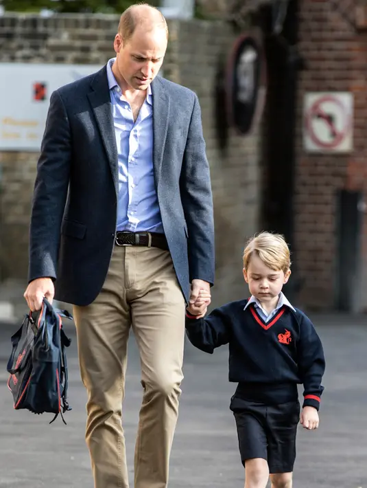 Pangeran William saat mengantar Pangeran George pada hari pertama sekolah di Thomas's school di Battersea, London, Inggris (7/9). Pengeran Goerge tidak ditemani ibunya Kate Middleton yang sedang hamil. (Richard Pohle/Pool Photo via AP)