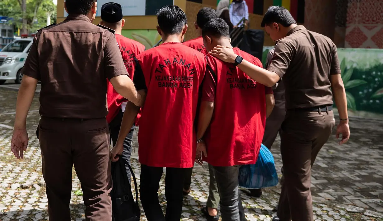 Para pria yang dihukum karena melanggar hukum Islam, di antaranya karena mencium seorang wanita saat siaran langsung TikTok, tiba untuk menjalani hukuman cambuk di Taman Bustanussalatin, Banda Aceh, Aceh, Kamis (2/7/2026). (AP Photo/Reza Saifullah)