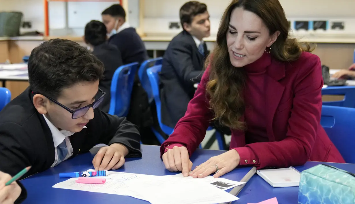 Kate Middleton, Duchess of Cambridge, berinteraksi dengan siswa selama kunjungan ke Nower Hill High School di Harrow, London utara (24/11/2021). Ia mengikuti pelajaran sains yang mempelajari ilmu saraf dan pentingnya perkembangan anak usia dini bersama para siswa. (AFP/Pool/Kirsty Wigglesworth)