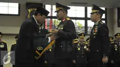 Menkopolhukam, Tedjo Edy Purdjianto (kiri) menyematkan tanda kehormatan Bintang Bhayangkara Utama ke Kapolri Jenderal Badrodin Haiti (tengah)di Jakarta, Senin (29/6/2015). (Liputan6.com/Herman Zakharia)