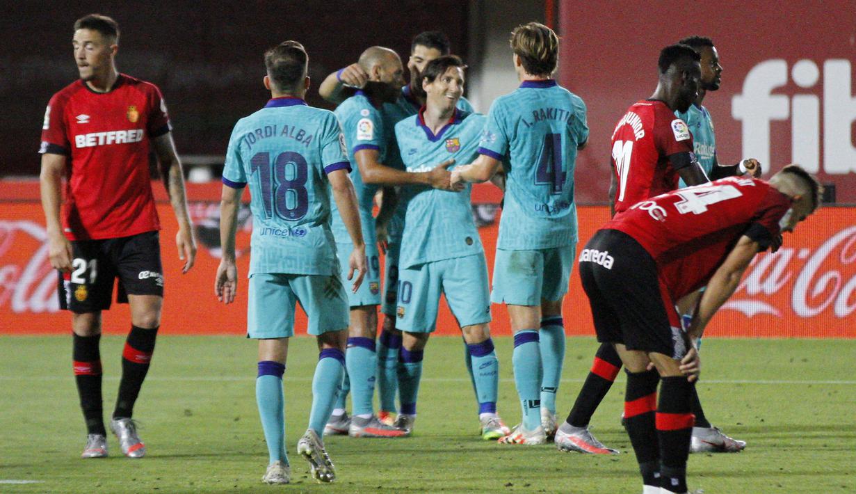 Para pemain Barcelona merayakan gol yang dicetak oleh Lionel Messi ke gawang Mallorca pada laga La Liga di Estadio de Son Moix, Minggu (14/6/2020). Barcelona menang dengan skor 4-0. (AP/Francisco Ubilla)