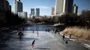 Sejumlah warga bermain ice skating di sungai yang membeku di Beijing, China (21/1). Akibat membeku, Sungai ini menjadi objek wisata dadakan yang banyak diminati wisatawan. (AFP/Fred Dufour)