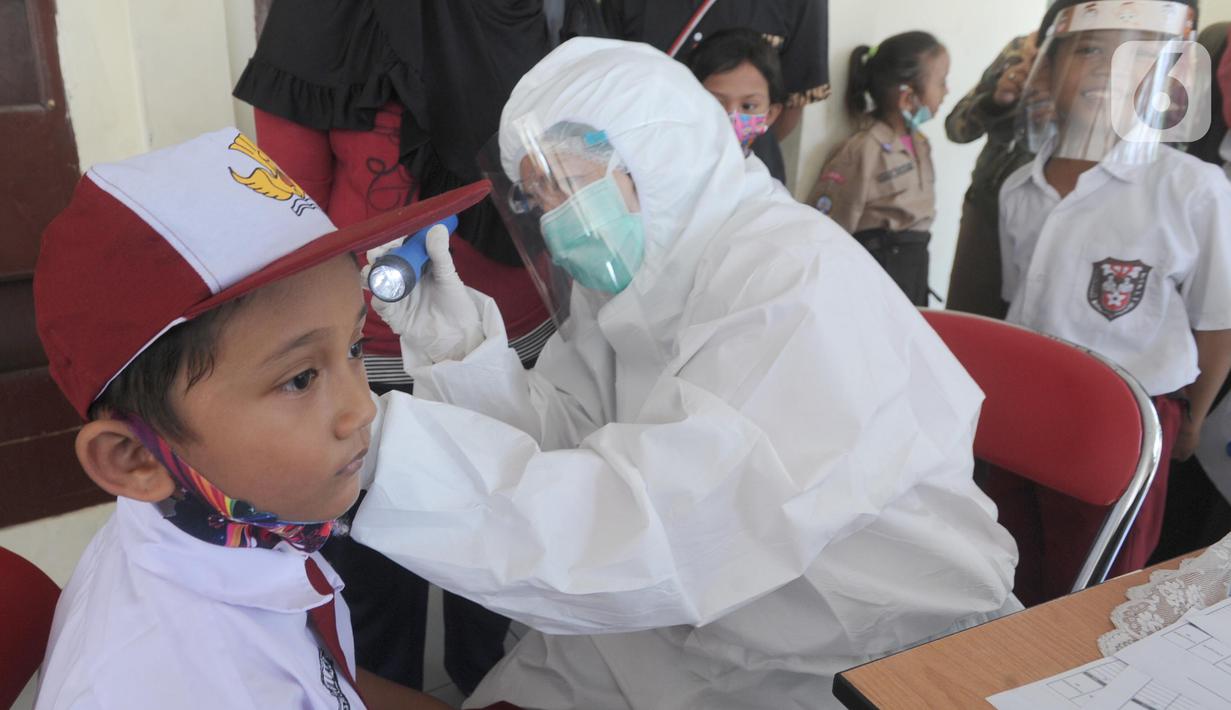 Tim medis puskesmas memeriksa murid Sekolah Dasar Negeri pada lingkungan Kecamatan Kebayoran Lama di GOR Kebayoran Lama, Jakarta, Rabu (26/08/2020). Kegiatan ini bagian dari bulan imunisasi anak sekolah dan juga pemeriksaan kesehatan menyeluruh kepada murid SDN di DKI. (merdeka.com/Arie Basuki)