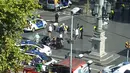 Petugas dibantu warga membantu korban setelah mobil van menabrak kerumunan orang  di Jalanan Las Ramblas, Barcelona, Spanyol (17/8). Lebih dari 50 orang dilaporkan luka-luka dan 13 orang tewas akibat kejadian tersebut. (Daniel Vil via AP)