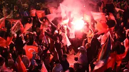 Pendukung Erdogan merayakan kemenangan dalam referendum di Istanbul, Turki (16/4). Turki telah menggelar referendum menentukan setuju atau tidak sistem pemerintahan negara presidensil parlementer berganti presidensil absolut. (AFP Photo / Ozan Kose)
