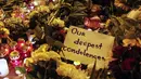 Sebuah  ucapan belasungkawa diletakkan diantara lilin dan karangan bunga di depan Kedubes Belanda di Ukraina, Jumat (18/7/14). (REUTERS/Valentyn Ogirenko)