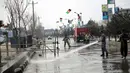 Polisi dan pemadam kebakaran membersihkan lokasi serangan bom bunuh diri di Kabul (9/3). Seorang pembom bunuh diri yang menargetkan kelompok minoritas Afghanistan, Hazaras, meledakkan dirinya di sebuah pos pemeriksaan polisi. (AP Photo / Massoud Hossaini)