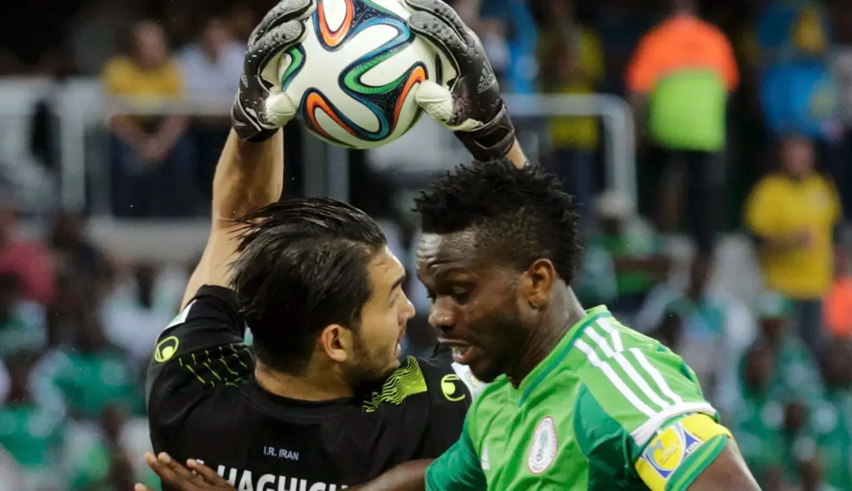 Penjaga gawang Iran, Alireza Haghighi (kiri) berhasil menahan bola yang mengarah ke Joseph Yobo (Nigeria) saat berlaga di babak penyisihan Piala Dunia Grup F, Baixada Arena, Brasil, (17/6/2014). (REUTERS/Henry Romero)