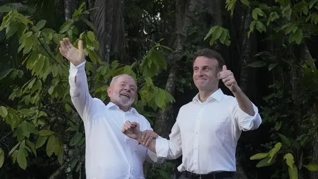 Presiden Brasil Lula da Silva dan Presiden Prancis Emmanuel Macron saat berada di Combu Island, dekat Belem, Negara Bagian Para, Brasil, pada Selasa (26/3/2024).