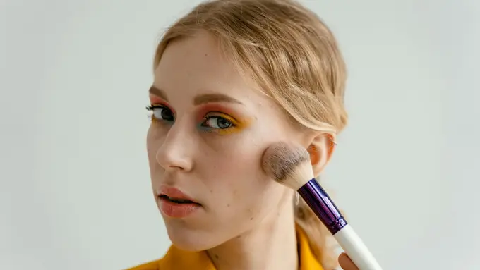 Perempuan sedang merias wajah