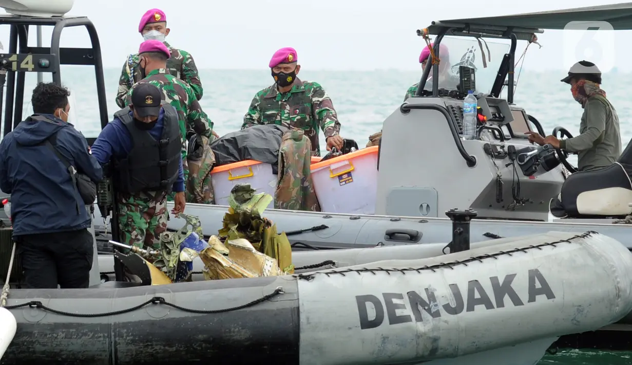 Tim SAR gabungan menaikkan serpihan pesawat Sriwijaya Air SJ 182 dari dalam air ke perahu karet di perairan Kepulauan Seribu, Jakarta, Minggu (10/1/20221). Sriwijaya Air SJ 182 hilang kontak dalam penerbangan dari Jakarta menuju Pontianak. (merdeka.com/Arie Basuki)
