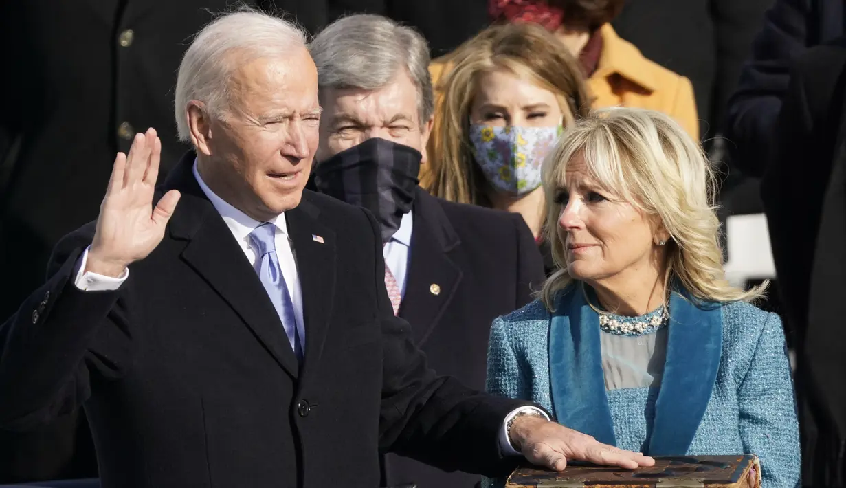 Presiden AS terpilih Joe Biden didampingi istri  Jill Biden saat dilantik oleh Ketua Mahkamah Agung John Roberts di US Capitol di Washington, Rabu (21/1/2021). Biden kini resmi menjabat sebagai Presiden ke-46 Amerika Serikat. (AP Photo/Andrew Harnik)