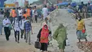 Orang-orang berjalan untuk naik feri menuju kota asal mereka setelah pelonggaran lockdown nasional COVID-19 di Sreenagar, Selasa (13/7/2021). Pemerintah Bangladesh melonggarkan lockdown yang sedang berlangsung selama seminggu mulai 15 hingga 22 Juli untuk perayaan Idul Adha. (Munir Uz zaman/AFP)