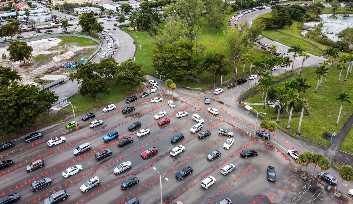 Dalam pandangan udara ini mobil berbaris di lokasi pengujian Covid-19 di Tropical Park di Miami, Florida, Selasa (21/12/2021). Beberapa hari sebelum Natal, orang Amerika menghadapi antrean panjang untuk dites virus corona di tengah lonjakan baru yang didorong oleh varian Omicron (CHANDAN KHANNA/AFP)