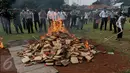 Petugas membakar kemasan ganja di Mapolsek Palmerah, Jakarta Barat, Senin (15/6/2015). Barang bukti yang dimusnahkan berupa 10.286 botol miras, 561 kg ganja, 1,4 kg sabu, 7.668 butir ekstasi, 1.000 butir psikotropika. (Liputan6.com/Johan Tallo)