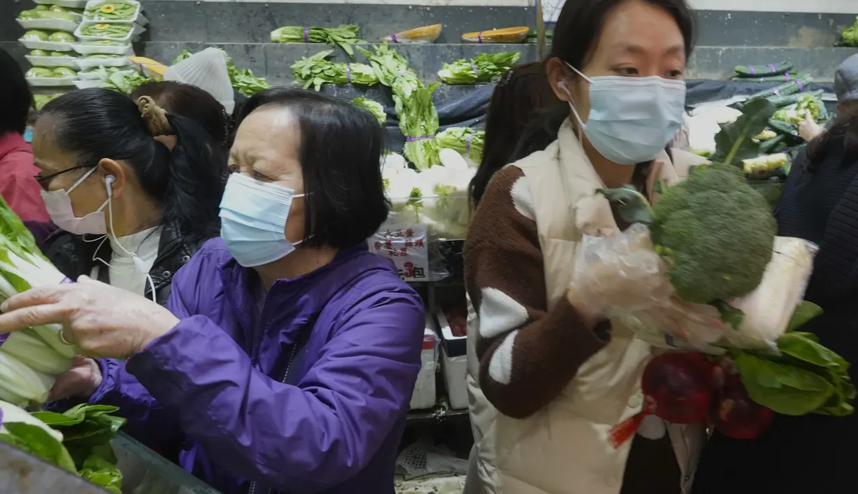 Pelanggan mengenakan masker, membeli sayuran segar di toko pasar basah di Hong Kong, Rabu, 9 Februari 2022. Hong Kong memberlakukan langkah-langkah jarak sosial yang paling ketat untuk mempertahankan kebijakan nol COVID-19 di tengah lonjakan kasus yang dipicu Varian Omicron. (AP Photo/Vincent Yu)