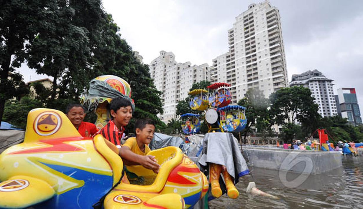 Tingginya curah hujan di wilayah Jakarta mengakibatkan sejumlah daerah masih terendam banjir, Jakarta, Selasa (10/2). Tampak sejumlah anak bermain di lahan bermain Kemayoran yang terendam banjir. (Liputan6.com/Faizal Fanani)