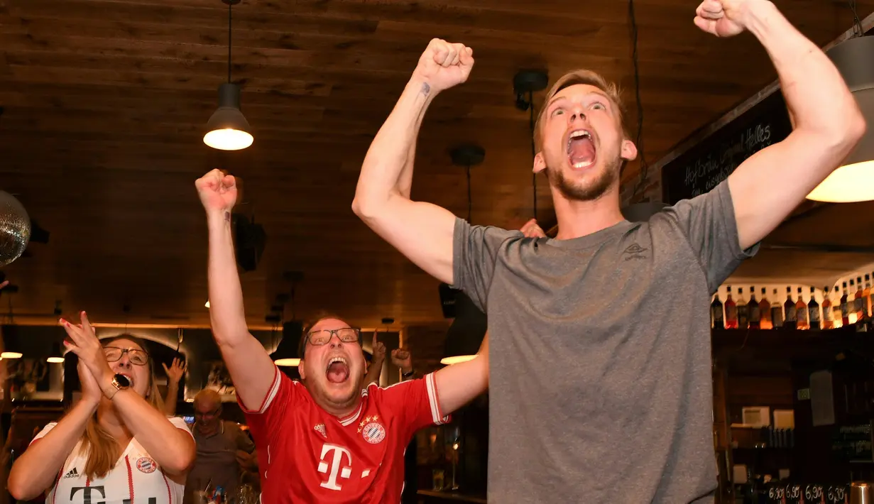Pendukung Bayern Munchen merayakan gol yang dicetak gelandang Kingsley Coman ke gawang PSG pada pertandingan final Liga Champions di sebuah restoran di Munich, Jerman, (23/8/2020). Munchen menang 1-0 atas PSG.  (Christof STACHE / AFP)