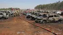 Petugas pemadam kebakaran memadamkan api yang membakar deretan mobil di area parkir pameran dirgantara Aero India 2019, Bangalore, India, Sabtu (23/2). Kebakaran diperparah dengan embusan angin yang kencang. (STR/AFP)