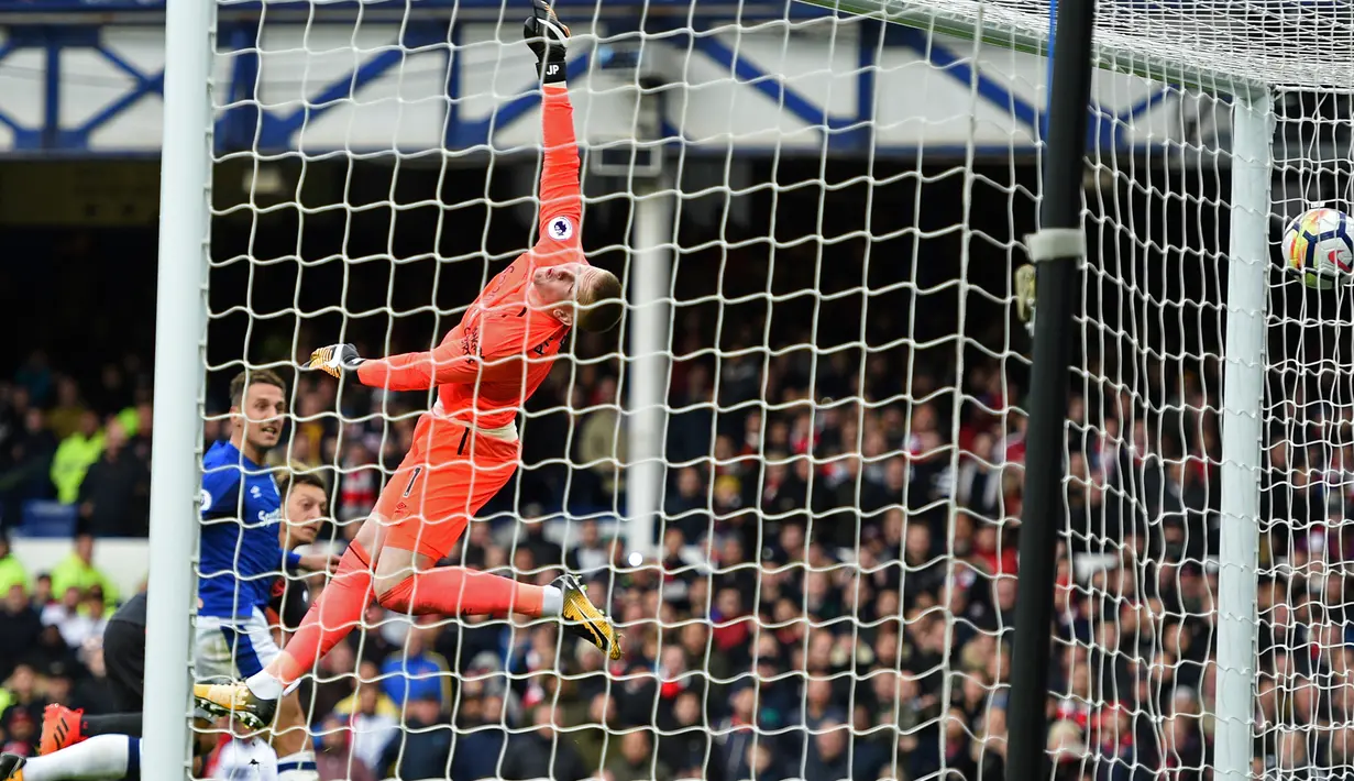 Kiper verton, Jordan Pickford gagal menangkap bola yang ditendang gelandang Arsenal, Mesut Ozil pada matchday kesembilan Liga Primer Inggris di Goodison Park, Minggu (22/10). The Gunners menang dengan skor akhir 5-2. (Oli SCARFF / AFP)