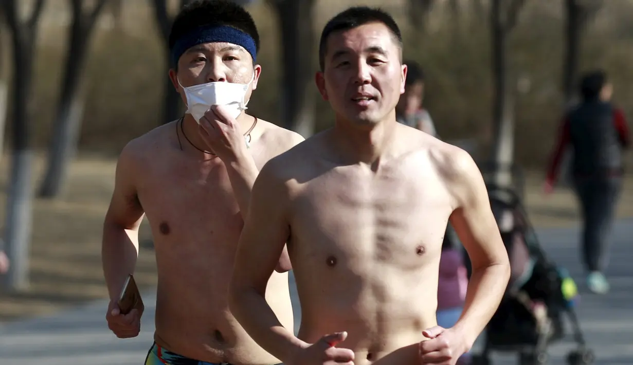 Peserta tak mengenakan baju saat  mengikuti lomba lari " Half- Naked Marathon" di Olympic Forest, Beijing, Cina, (28/2).  Lomba yang diselenggarakan tiap tahunnya ini sebagai bentuk gaya hidup ramah lingkungan. (REUTERS / Kim Kyung - Hoon)