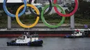 Kapal bersiap untuk menarik cincin Olimpiade saat dipindahkan dari area tepi laut di Taman Laut Odaiba setelah Olimpiade Musim Panas 2020 berakhir pada 8 Agustus di Tokyo, Rabu (11/8/2021). Setelah ini, Kota Paris akan menjadi tuan rumah olimpiade pada 2024 mendatang. (Kim Kyung-Hoon/Pool via AP)