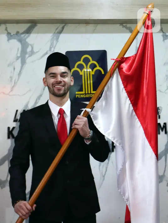 <p>Pemain sepak bola Sandy Walsh memegang bendera Merah Putih usai menjalani Sumpah Janji Setia Pewarganegaraan di Kantor Wilayah Kementerian Hukum dan HAM DKI Jakarta, Kamis (17/11/2022). Sandy Walsh resmi menjadi Warga Negara Indonesia (WNI) setelah prosesi pengambilan sumpah yang digelar secara tertutup. (Liputan6.com/Herman Zakharia)</p>