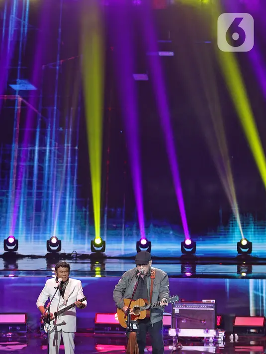 Penampilan penyanyi Rhoma Irama (kiri) dan Iwan Fals saat konser Pesta Perak 25 Indosiar di Jakarta, Minggu (12/1/2020). Rhoma Irama dan Iwan Fals berkolaborasi membawakan lagu Mirasantika, Buku Ini Aku Pinjam, Judi, dan Santai. (Liputan6.com/Herman Zakharia)