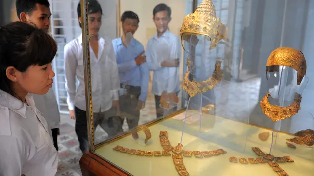 Pelajar Kamboja melihat emas dan batu kristal Royal Regalia dari periode Angkor, abad ke-12 dan ke-13