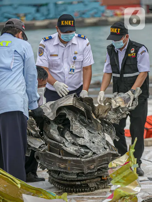 Petugas KNKT memeriksa bagian turbin pesawat Sriwijaya Air dihari kelima yang jatuh di perairan Pulau Seribu, di Dermaga JICT, Jakarta,  Rabu (13/1/2021). Pengangkatan mesin turbin pesawat Sriwijaya Air SJ 182 itu menggunakan crane milik KRI Cucut 866. (Liputan6.com/Faizal Fanani)