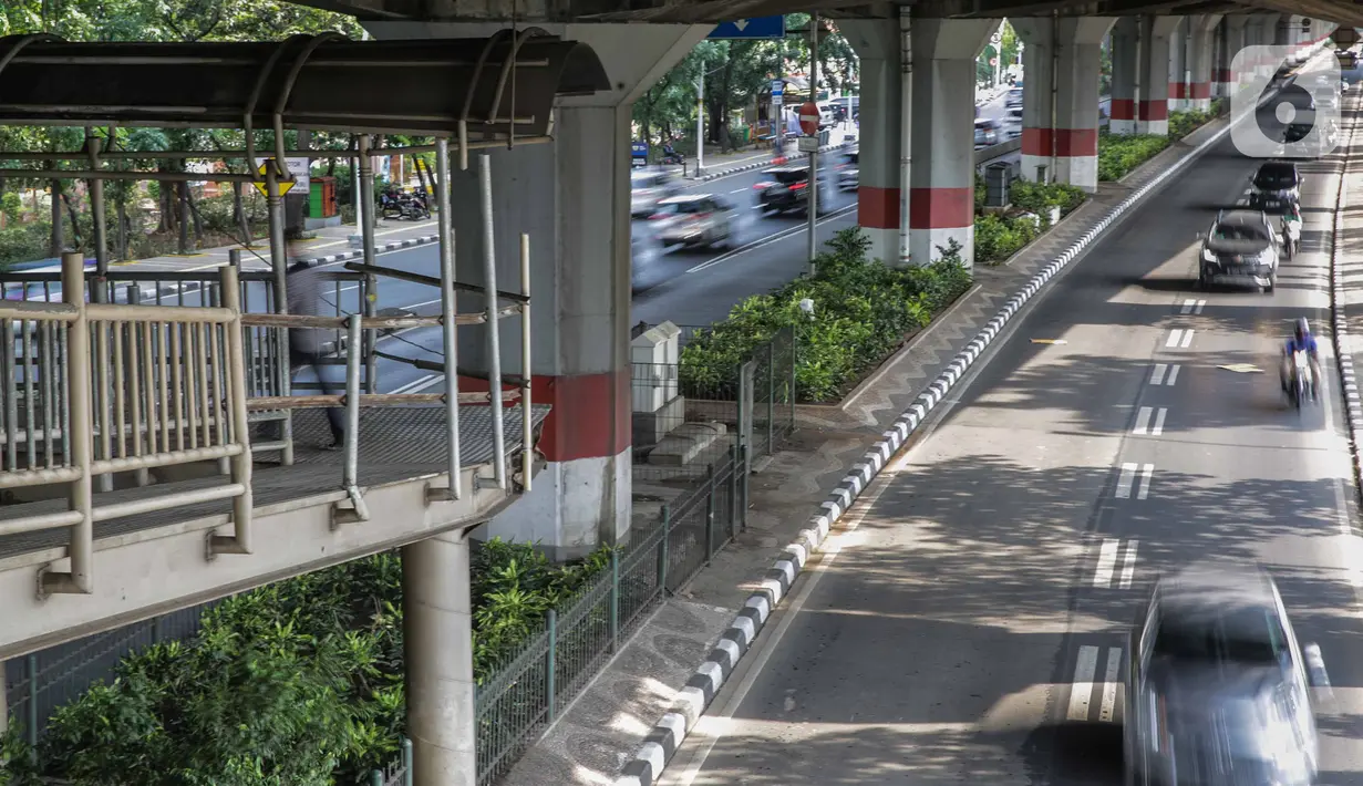 Pejalan kaki melintas di jembatan penyeberangan orang (JPO) halte transjakarta Bea Cukai di Jalan Ahmad Yani, Jatinegara, Jakarta, Kamis (5/12/2019). Sementara ini JPO hanya dipasang besi seadanya sebagai pengaman untuk para pengguna yang melintasi jembatan tersebut. (Liputan6.com/Faizal Fanani)